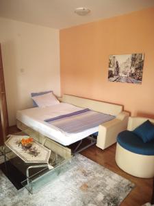 a small bedroom with a bed and a chair at Apartman Ozi in Petrovac na Moru