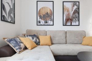 uma sala de estar com um sofá e quatro fotografias na parede em Chill 4 Real Sea View Mandre em Mandre