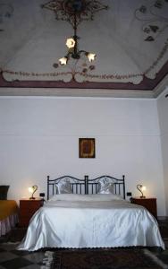 a bedroom with a bed with white sheets and a ceiling at Bed & Breakfast Casa Pisanu in Narbolia