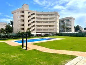 a building with a swimming pool in front of a building at Apartamento con Piscina y Jardín Espectacular Cala Sirenas - Nuevo in Miami Platja