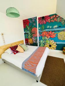 a bedroom with a bed with a colorful wall at Coco bay in Saint-Benoît-des-Ondes