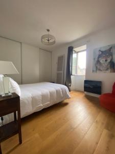 een slaapkamer met een wit bed en een raam bij Coeur Cité Médiévale Appart' 2- 4 personnes "La Salamandre" 80 m2 à 20m de la Mairie in Sarlat-la-Canéda