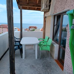 einen Tisch und Stühle auf einem Balkon mit Meerblick in der Unterkunft Guest House Olimpiya in Sweti Wlas