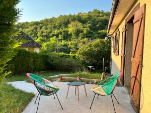 two chairs and a table sitting on a patio at Maison chaleureuse dans un écrin de verdure 