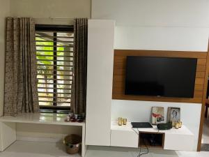 sala de estar con TV de pantalla plana en la pared en ASMA en Ahmedabad
