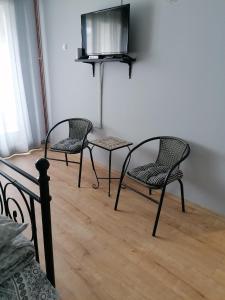 Duas cadeiras e uma mesa com uma televisão na parede em Stan na dan em Pozarevac