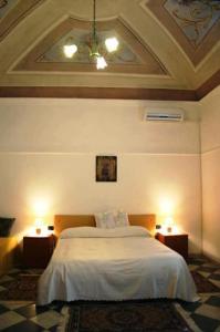 a bedroom with a bed and two night stands with lights at Bed & Breakfast Casa Pisanu in Narbolia