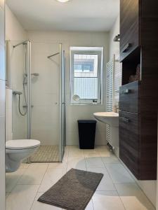 uma casa de banho com um chuveiro, um WC e um lavatório. em FeWo Am Ring - mit Terrasse em Nordhorn