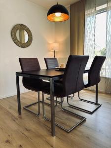 a dining room table with black chairs and a mirror at FeWo Am Ring - mit Terrasse in Nordhorn