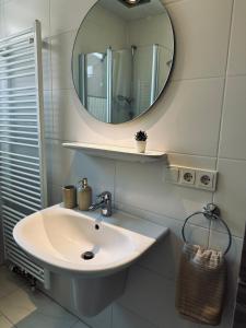 W łazience znajduje się umywalka i lustro. w obiekcie FeWo Am Ring - mit Terrasse w mieście Nordhorn