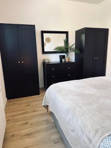 a bedroom with black cabinets and a white bed at FeWo Am Ring - mit Terrasse in Nordhorn