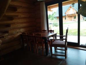 malinowy beret في Zatwarnica: طاولة وكراسي خشبية في غرفة مع نافذة