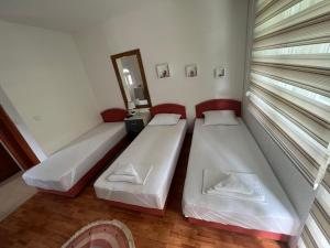 two beds in a small room with a window at Apartman Tristan in Herceg-Novi