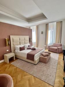 ein großes Schlafzimmer mit einem großen Bett und einem Stuhl in der Unterkunft Màs Boutique Hotel Rome in Rom