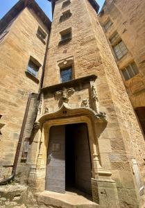 een stenen gebouw met een deur ervoor bij Coeur Cité Médiévale Appart' 2- 4 personnes "La Salamandre" 80 m2 à 20m de la Mairie in Sarlat-la-Canéda