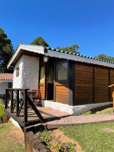 a small cabin with a wooden deck in front of it at Canto do Vento Hospedaria in Santo Antônio do Pinhal