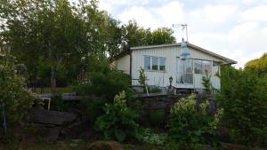 a white house with glass windows and trees at The Lake in Alingsås