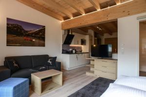 a living room with a couch and a tv at R Appartements in Tannheim