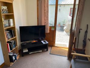 a living room with a television and a door to a patio at Yairbrig Holiday in Galashiels