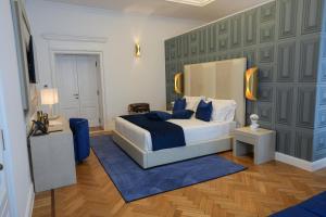 a bedroom with a king sized bed and a blue rug at Màs Boutique Hotel Rome in Rome