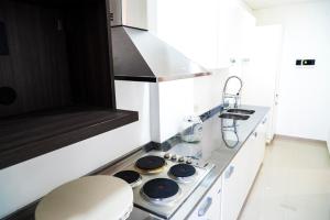 een witte keuken met een fornuis en een wastafel bij Edificio Mia Victoria in Oberá