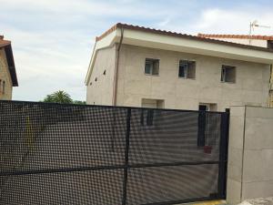 budynek z płotem przed budynkiem w obiekcie Casa San Miguel 93 santander w mieście Santander