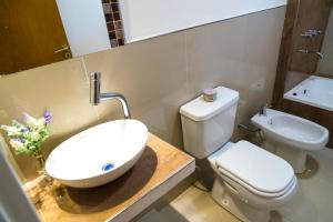 a bathroom with a white toilet and a sink at Edificio Mia Victoria in Oberá