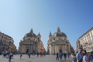 un gruppo di persone che camminano davanti a due edifici di Màs Boutique Hotel Rome a Roma