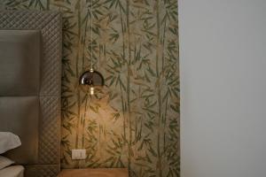 a light hanging from a wall with a wallpaper at Màs Boutique Hotel Rome in Rome