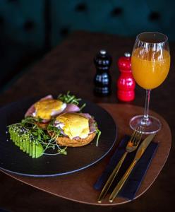 斯普利特City and Style Luxury Rooms Split 2的盘子上放着三明治和一杯橙汁