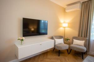 sala de estar con TV de pantalla plana y 2 sillas en City and Style Luxury Rooms Split 2 en Split
