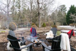 eine Gruppe von Stühlen, die um ein Feuer im Hof herum sitzen in der Unterkunft Casa Carolina Estate in Hendersonville