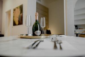 a bottle of wine on a table with two wine glasses at Màs Boutique Hotel Rome in Rome