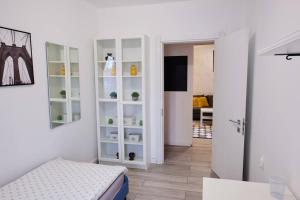 une pièce avec une armoire blanche avec des étagères et une porte dans l'établissement Joy City Stay Versului 8, à Timişoara