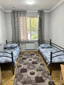 a bedroom with two beds and a rug at Guest house Family7 in Osh