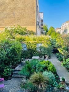 un jardín con bancos y plantas en una ciudad en Camden Town Garden Cabin en Londres