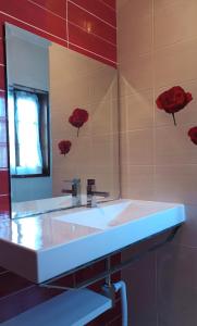 ein Badezimmer mit einem weißen Waschbecken und einem Spiegel in der Unterkunft Casa do Cadaval in Rio Caldo