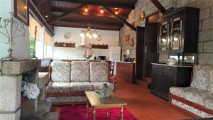 ein Wohnzimmer mit einem Sofa und einem Tisch in der Unterkunft Casa do Cadaval in Rio Caldo