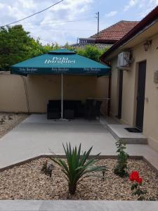 niebieski parasol na patio w obiekcie CasaRiana 4 w mieście Eforie Sud