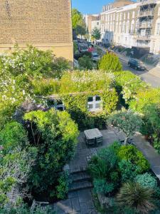 ロンドンにあるカムデン タウン ガーデン キャビンのベンチと花のある庭園の景色を望めます。
