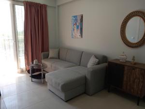 a living room with a couch and a mirror at Bella Luxury Suite in Paralia Katerinis