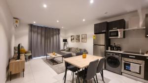 a kitchen and living room with a table and a couch at The Lennox Suites by Cozy in Accra