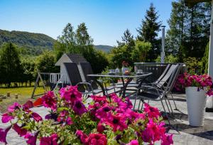 a patio with a table and chairs and flowers at Domek Veron in Wysowa-Zdrój