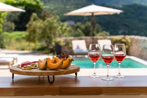 a table with two glasses of wine and a plate of fruit at villa du Passeron in Chambonas