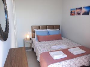 a bedroom with a bed with two towels on it at Bella Luxury Suite in Paralia Katerinis