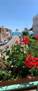 un ramo de flores rojas en una plantadora en una calle en Hôtel La Villa des Oliviers, en Cagnes-sur-Mer