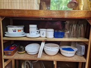a shelf with plates and bowls and other dishes at Hausboot Hans im Glück in Hundsdorf