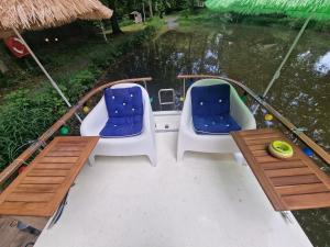 a boat with two chairs and a table on the water at Hausboot Hans im Glück in Hundsdorf