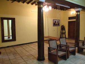 um quarto com duas cadeiras e um grande poste em Elite Heritage Stay em Pondicherry