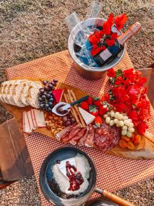 eine Platte mit Käse und Fleisch auf dem Tisch in der Unterkunft Canto do Vento Hospedaria in Santo Antônio do Pinhal